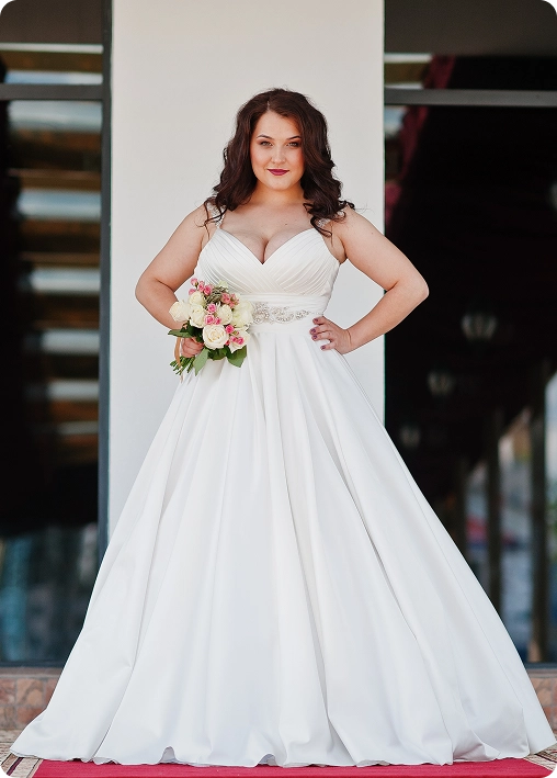 Plus-size bride in a white gown with bouquet, representing Ashley Stewart’s successful bridal campaign led by BrandLoom